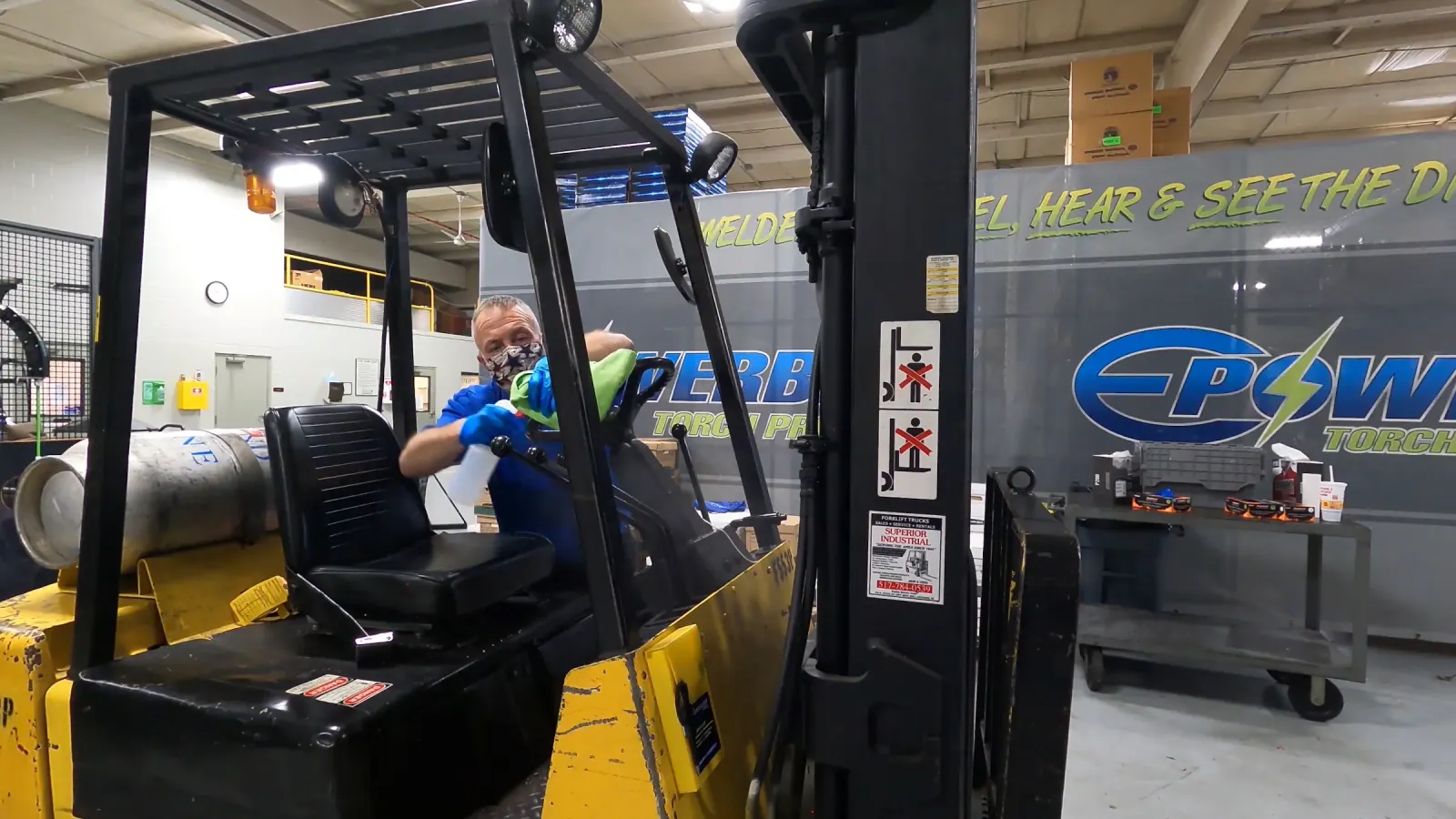 SWAT technician treating forklift touch points during a sanitation service